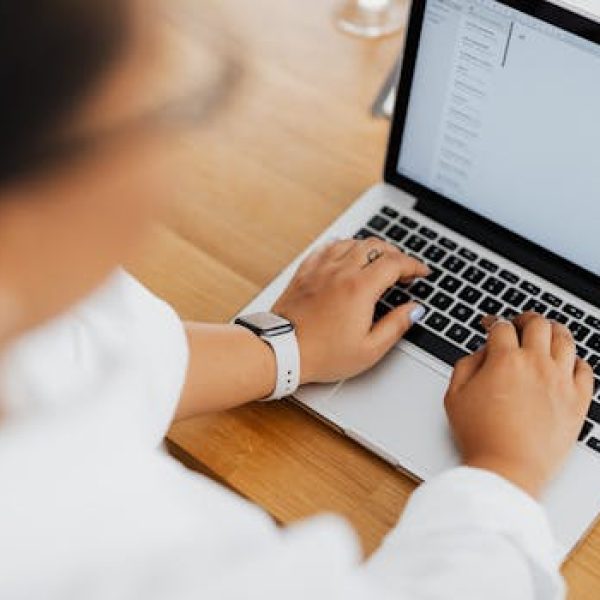 High angle shot of a person typing on a laptop, focused on hands and keyboard.